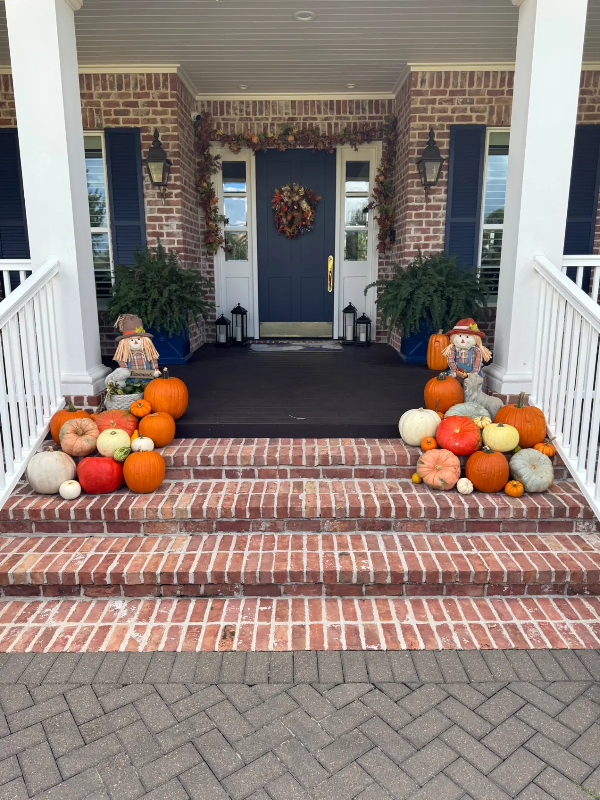 Brick front steps framed with pumpkins on both sides, styled by West Pumpkin Bros