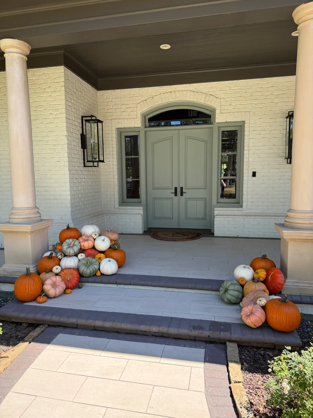 A styled Medium pumpkin display on a front porch.