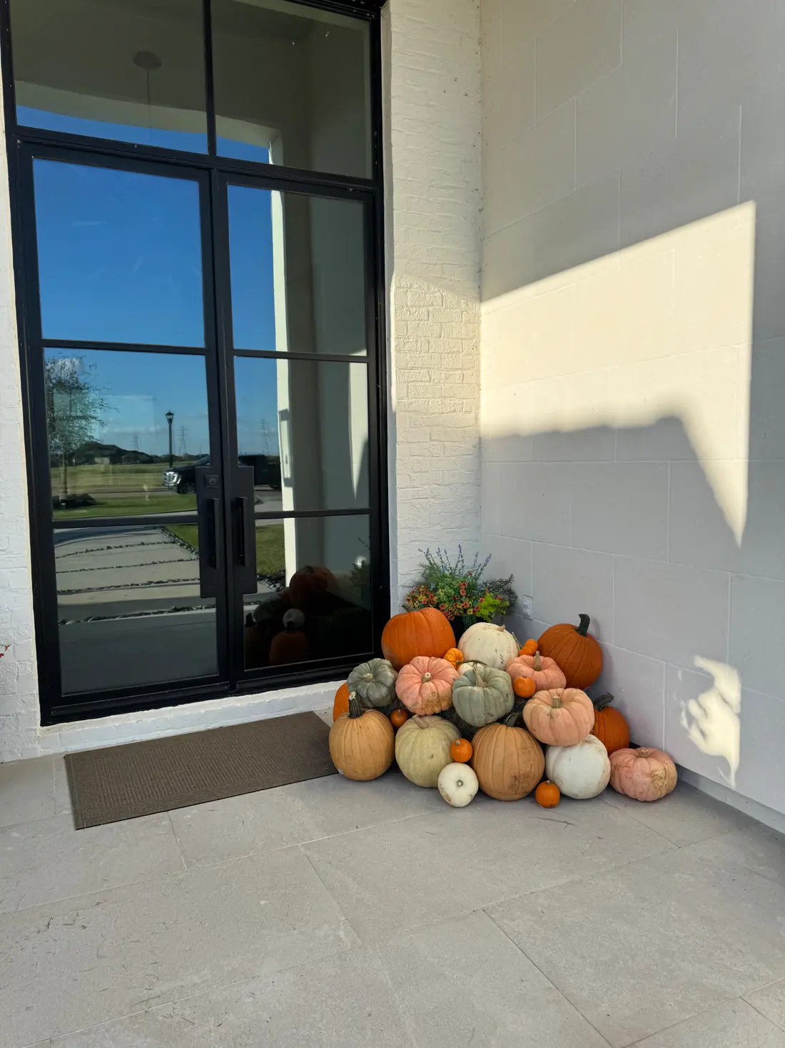 A styled Small pumpkin display on a front porch.